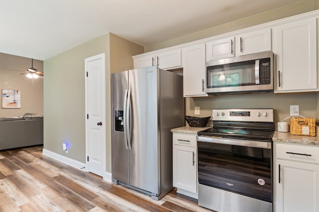 kitchen featuring ceiling fan, white cabinets, stainless steel appliances, and light wood-type flooring