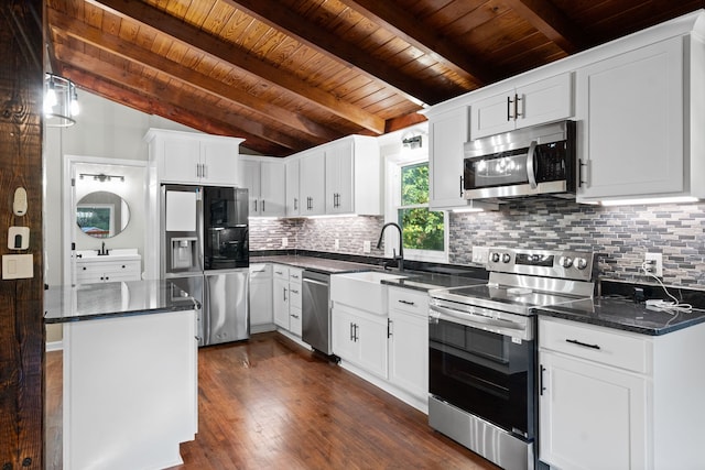 kitchen with a center island, sink, white cabinets, appliances with stainless steel finishes, and dark hardwood / wood-style flooring