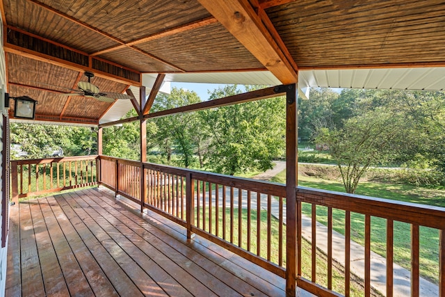 wooden terrace featuring a lawn and ceiling fan