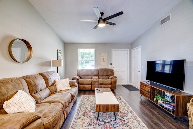 living room with ceiling fan, vaulted ceiling, a textured ceiling, and dark hardwood / wood-style flooring