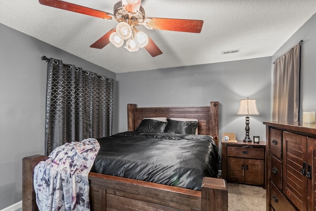 bedroom featuring a textured ceiling, ceiling fan, and light colored carpet