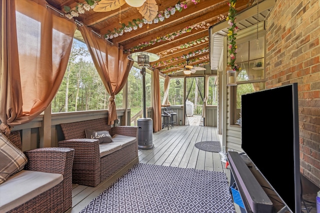 sunroom / solarium featuring lofted ceiling with beams and ceiling fan