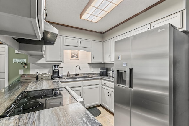 kitchen with sink, white cabinetry, stainless steel refrigerator with ice dispenser, black stovetop, and crown molding