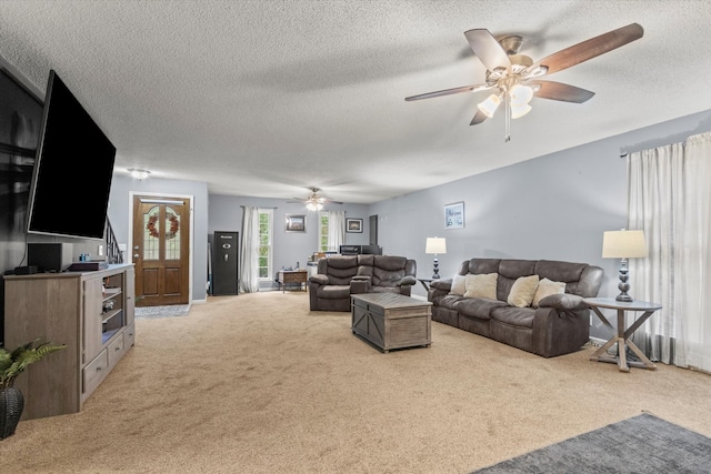 carpeted living room featuring ceiling fan and a textured ceiling