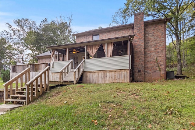 view of front facade with cooling unit, a deck, ceiling fan, and a front yard