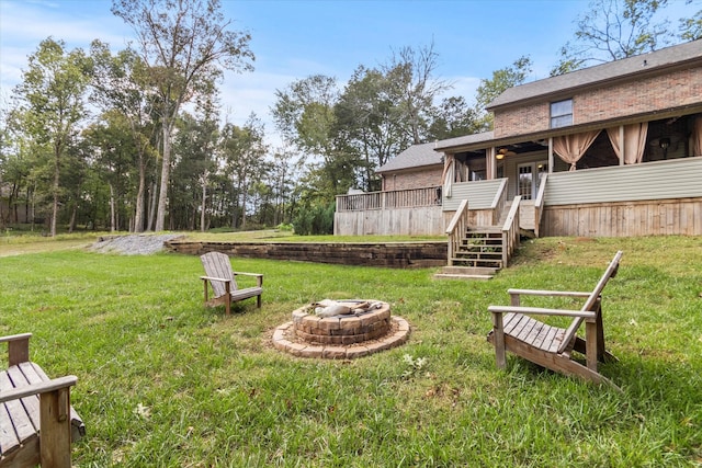 view of yard with a wooden deck and an outdoor fire pit