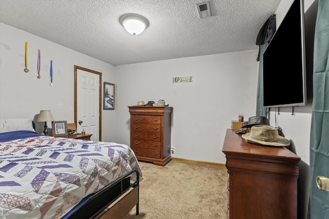 bedroom with light colored carpet and a textured ceiling