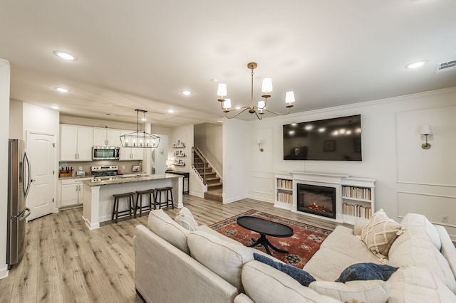 living room featuring ornamental molding, light wood-type flooring, and sink