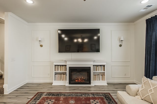 unfurnished living room featuring hardwood / wood-style flooring and crown molding