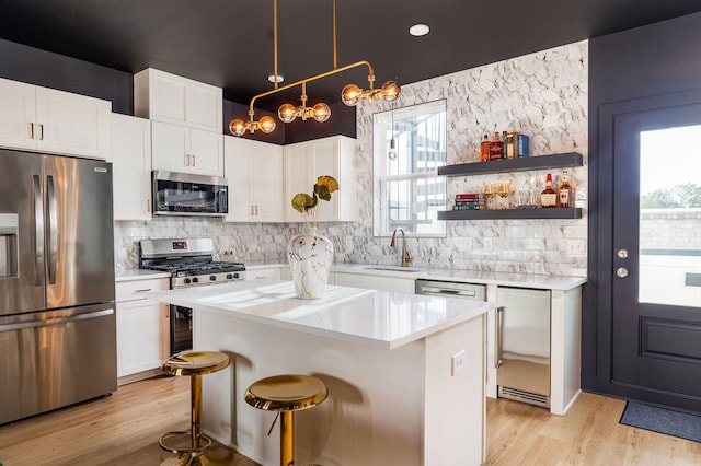 kitchen featuring pendant lighting, a wealth of natural light, a center island, and appliances with stainless steel finishes