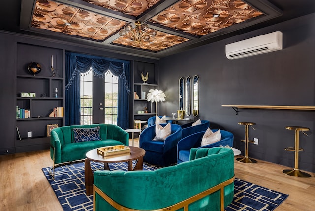 sitting room featuring built in features, coffered ceiling, crown molding, hardwood / wood-style floors, and an AC wall unit