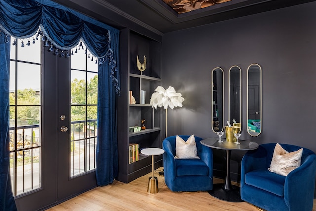 sitting room featuring ornamental molding, hardwood / wood-style floors, built in features, and french doors