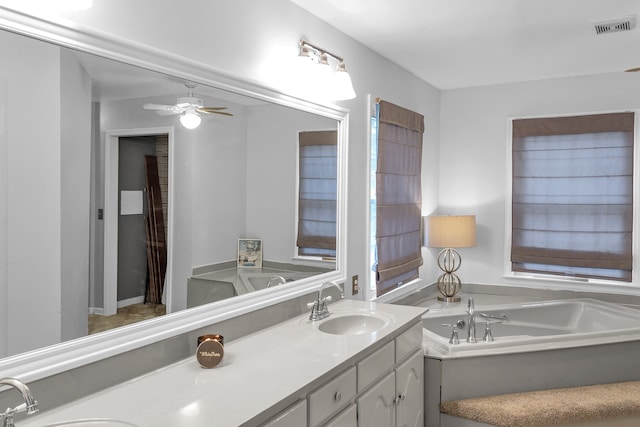 bathroom featuring ceiling fan, vanity, and a tub to relax in