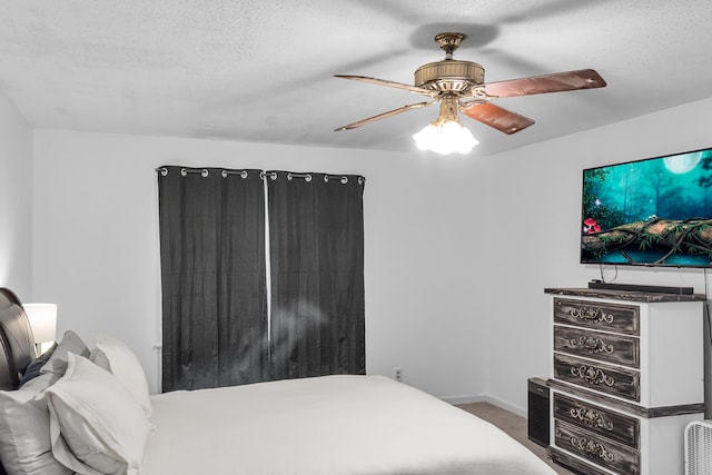 bedroom featuring ceiling fan, a textured ceiling, and hardwood / wood-style flooring