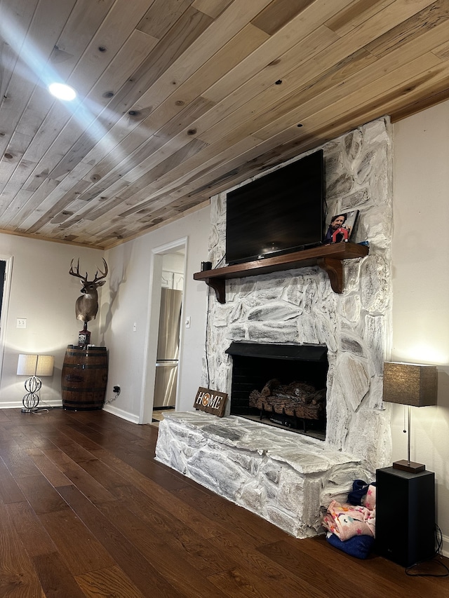 interior space with wood-type flooring, wooden ceiling, and a stone fireplace