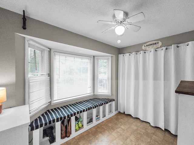 bathroom with ceiling fan and a textured ceiling