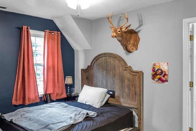 bedroom featuring lofted ceiling and a textured ceiling