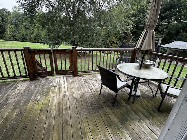 wooden deck featuring a lawn