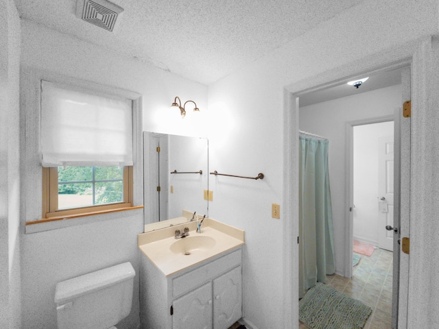 bathroom featuring vanity, toilet, and a textured ceiling