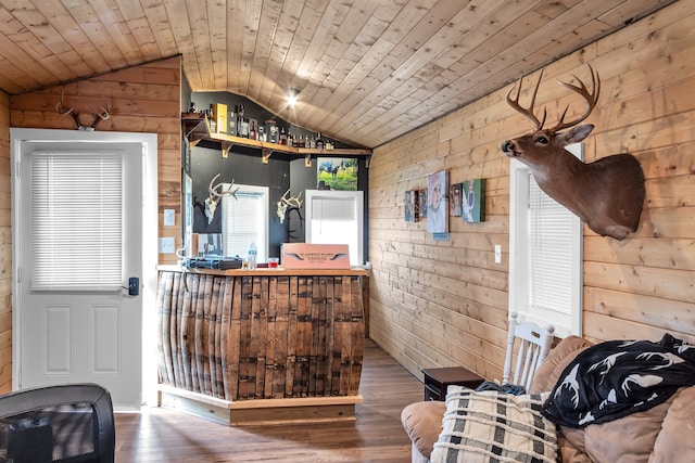 interior space with hardwood / wood-style flooring, wooden walls, vaulted ceiling, and wooden ceiling