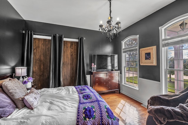 bedroom with light hardwood / wood-style flooring and a notable chandelier