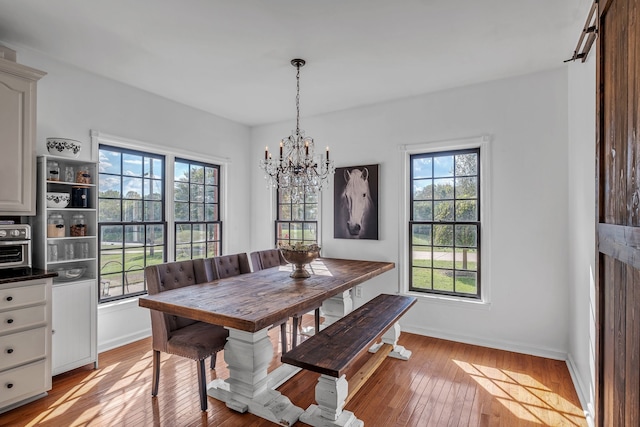 dining area featuring an inviting chandelier and light hardwood / wood-style floors