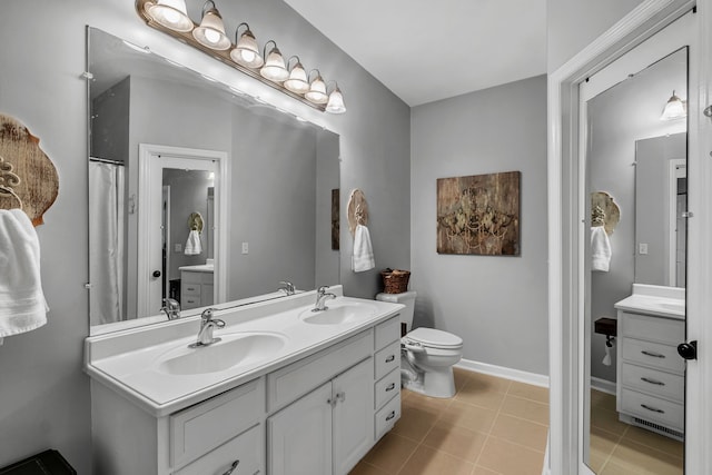 bathroom with vanity, toilet, and tile patterned floors