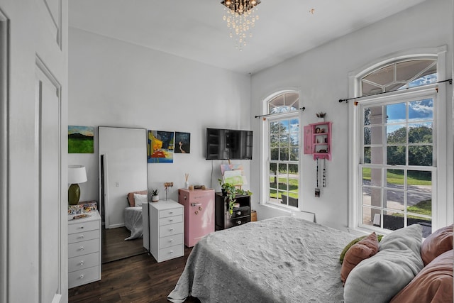 bedroom with an inviting chandelier, multiple windows, and dark hardwood / wood-style floors