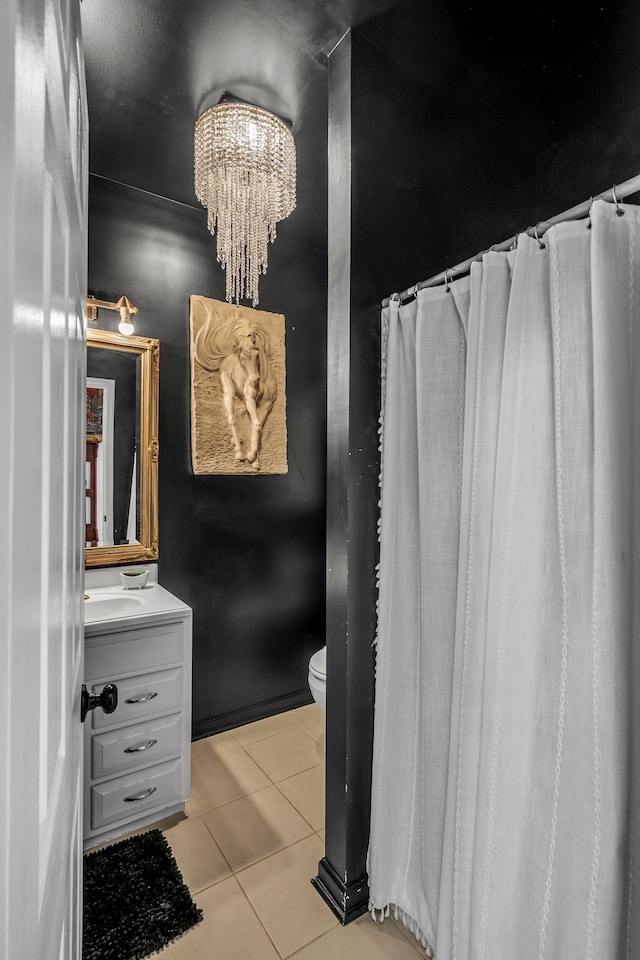 bathroom with a notable chandelier, vanity, tile patterned flooring, and toilet