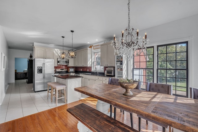 dining space featuring sink, plenty of natural light, light hardwood / wood-style floors, and a chandelier