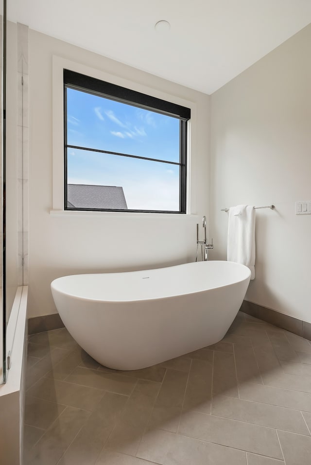 bathroom with a bathtub and tile patterned floors