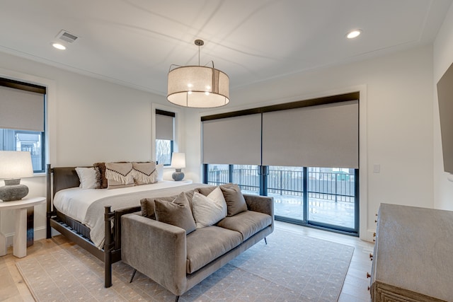 bedroom featuring multiple windows, light wood-type flooring, and access to exterior