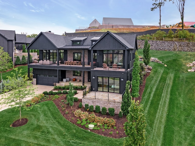 back of property with a lawn, a balcony, and a garage