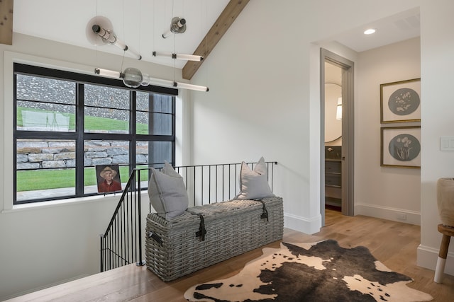 sitting room with vaulted ceiling with beams and wood-type flooring