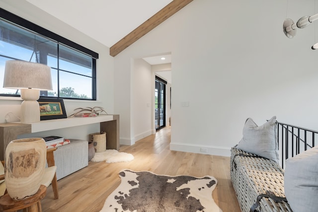 interior space featuring vaulted ceiling with beams and light hardwood / wood-style floors