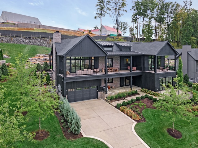 view of front of house featuring a balcony, a garage, and a front yard