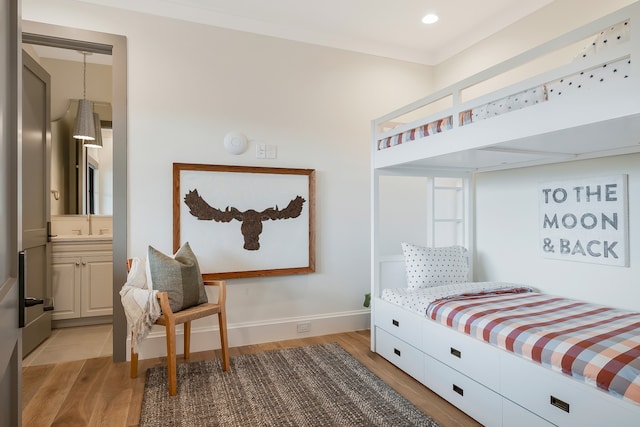 bedroom featuring light hardwood / wood-style flooring and connected bathroom