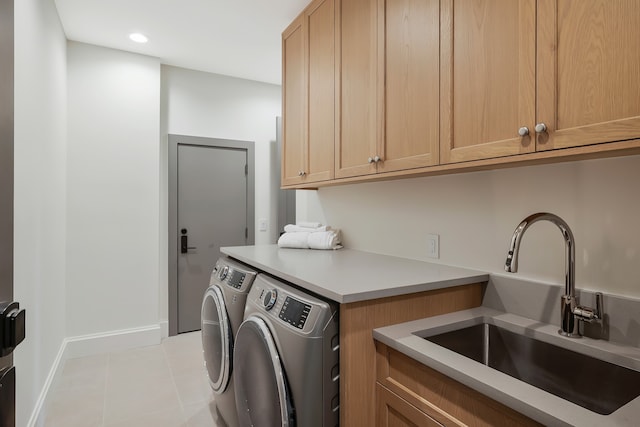 laundry area with cabinets, light tile patterned floors, sink, and washer and dryer