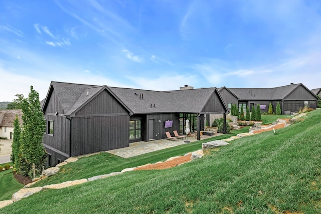 rear view of house featuring a yard and a patio