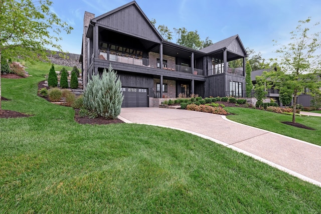 view of front of property featuring a garage, a balcony, and a front lawn