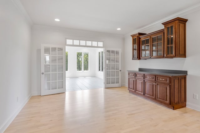 unfurnished dining area featuring french doors, light hardwood / wood-style flooring, and ornamental molding