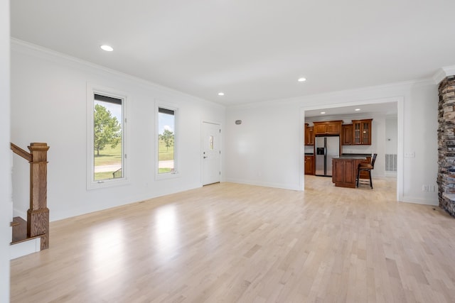 unfurnished living room with light wood-type flooring and ornamental molding