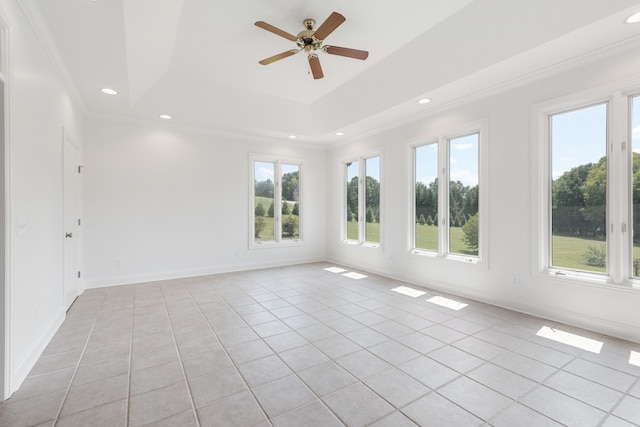 spare room with crown molding, ceiling fan, light tile patterned floors, and a raised ceiling