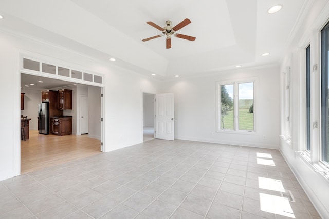 empty room featuring ceiling fan, crown molding, and light tile patterned floors