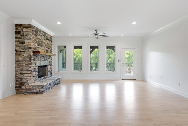 unfurnished living room with ceiling fan, a stone fireplace, light hardwood / wood-style flooring, and ornamental molding