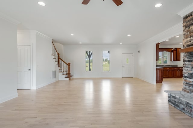 unfurnished living room with ornamental molding, light hardwood / wood-style flooring, and a healthy amount of sunlight