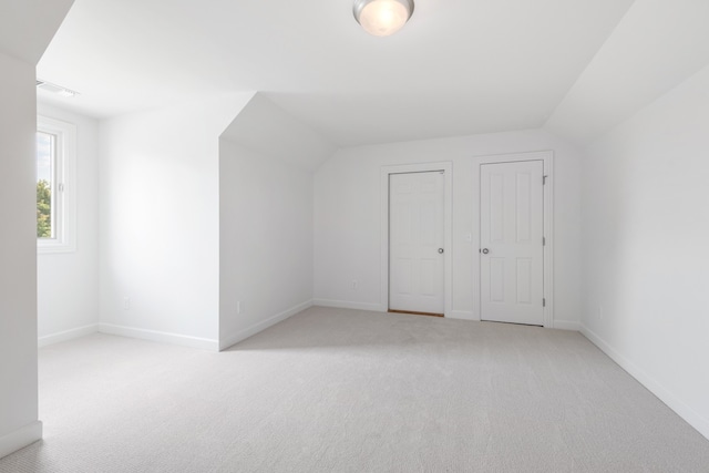 additional living space with light colored carpet and lofted ceiling