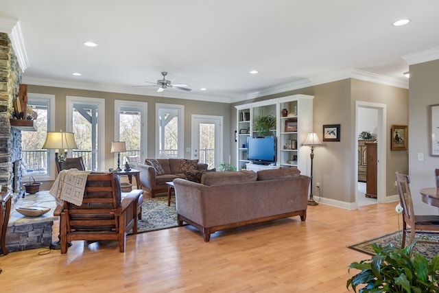 living room featuring ornamental molding, light wood-type flooring, and a healthy amount of sunlight