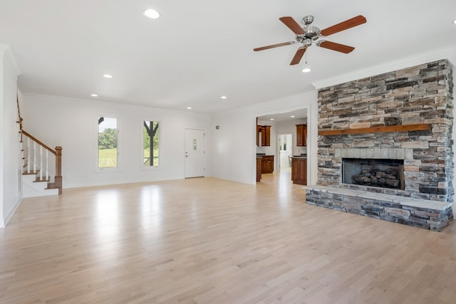 unfurnished living room with a fireplace, light hardwood / wood-style floors, ornamental molding, and ceiling fan