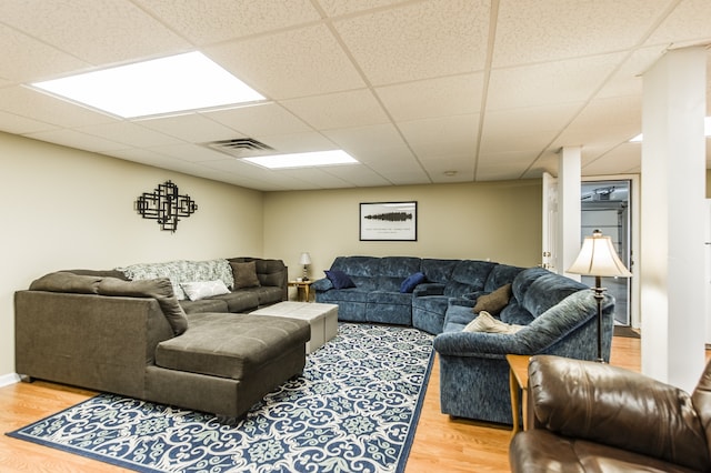 living room with hardwood / wood-style floors and a paneled ceiling